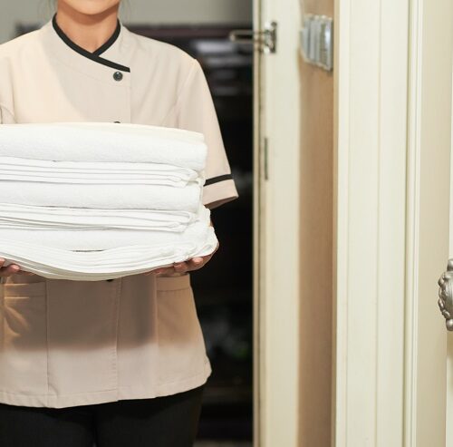Cropped image of woman with stack of fresh white towels